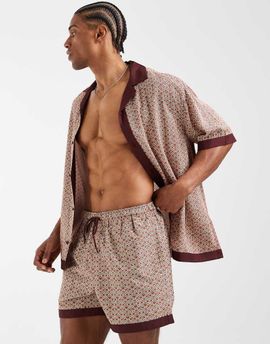 ASOS DESIGN ASOS DESIGN swim shorts in short length in orange geo print with border - part of a set