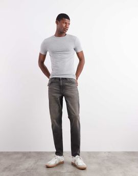 ASOS DESIGN ASOS DESIGN tapered fit jeans with yellow tint in washed black