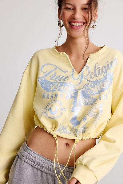 TRUE RELIGION True Religion Glitter Graphic Notch V-Neck Pullover Top in Double Cream, Women's at Urban Outfitters